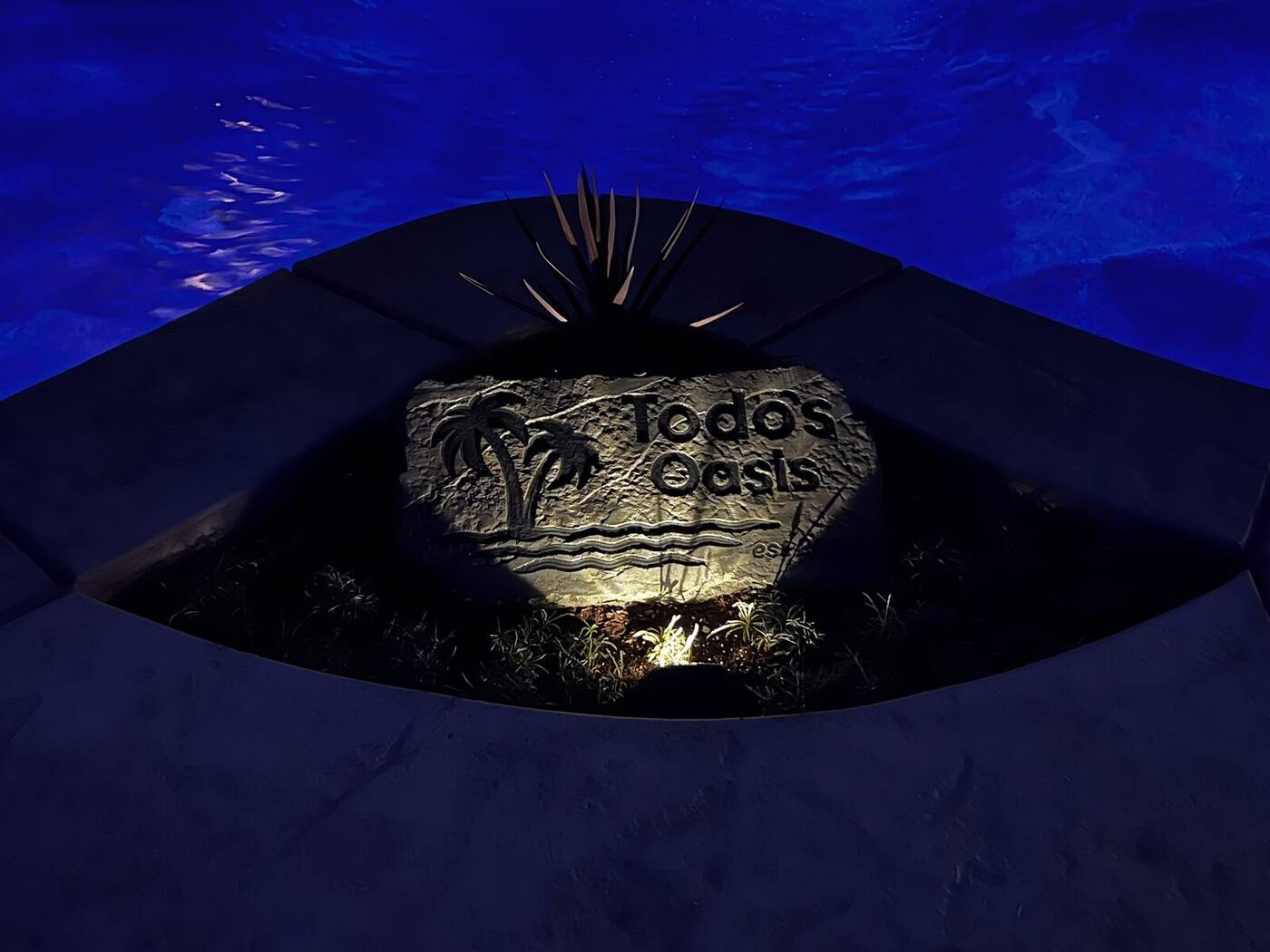 Custom engraved boulder sign uplit at night — Todo's Oasis, Southern California
