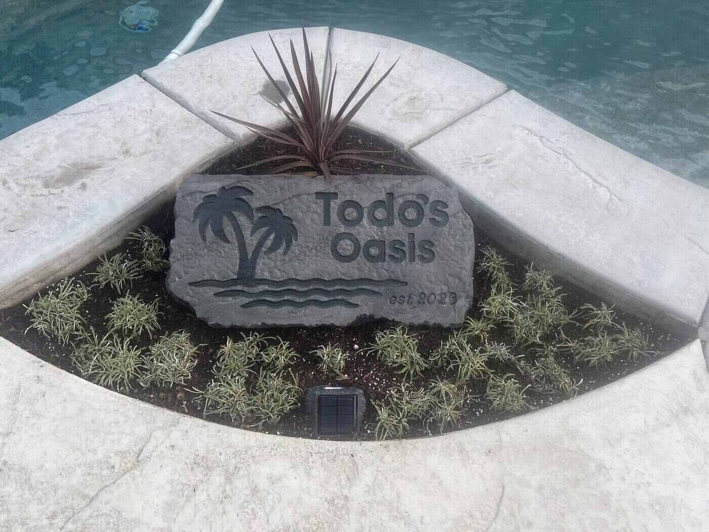 Engraved boulder sign set in a landscaped island