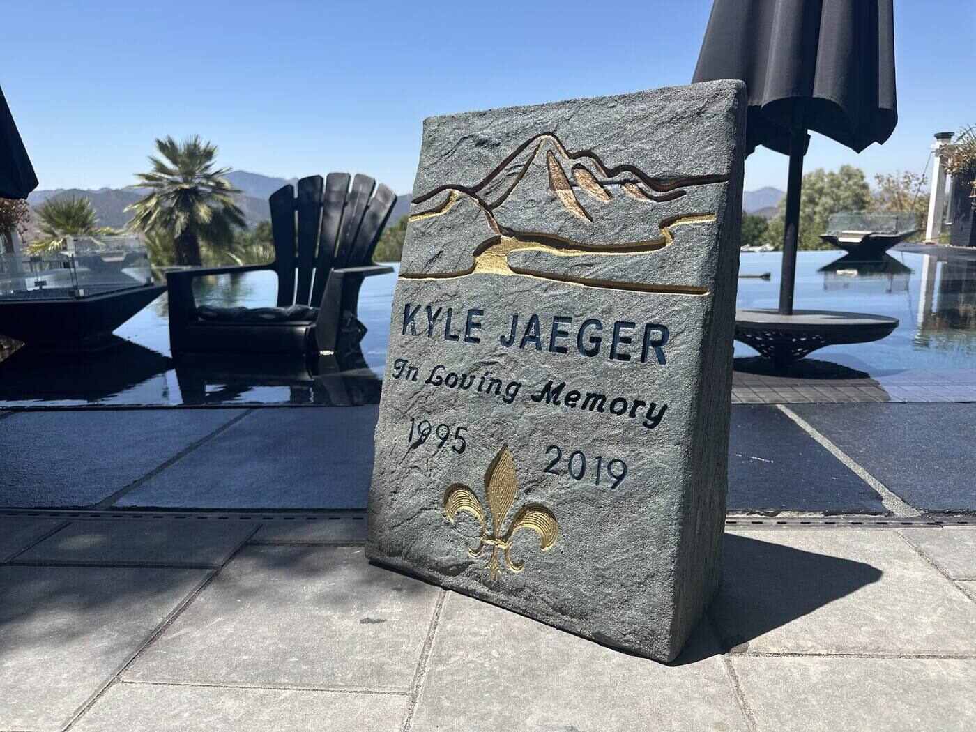 Custom memorial stone with engraved mountain scene and gold fleur-de-lis
